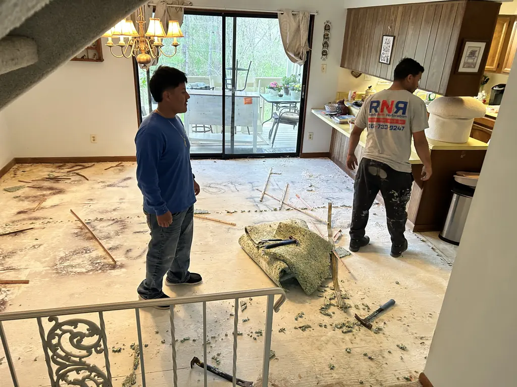 Crew members pulling out old carpet before new flooring in Knoxville, Tennessee