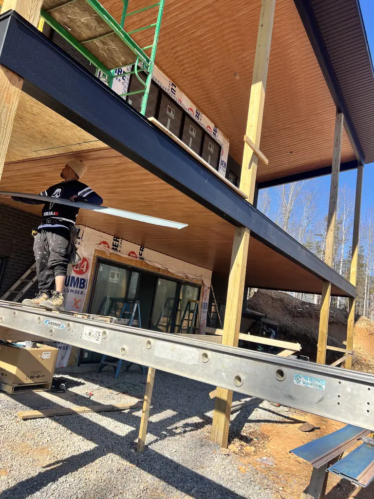 Crew member installing the header beam of a patio cover in Knoxville, Tennessee
