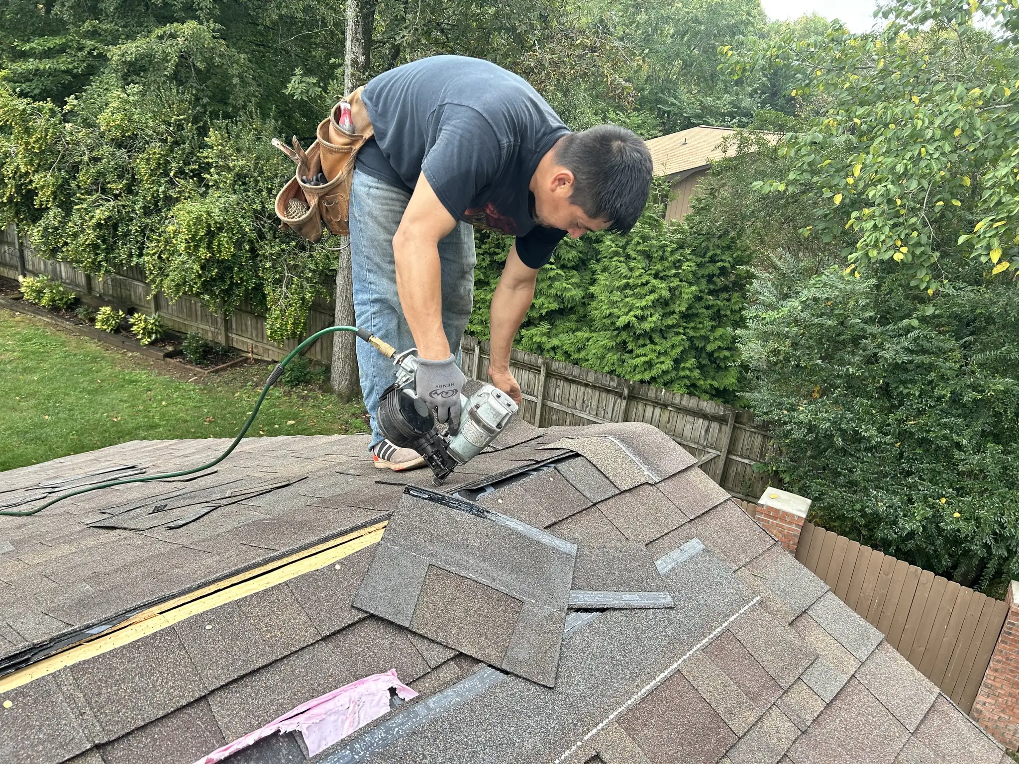 Chicanos Construction crew member nailing down shingles on a roof in Knoxville, Tennessee