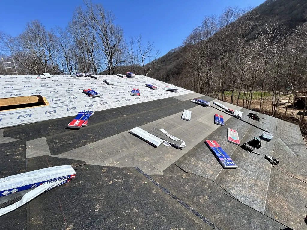 Shingle bundles staged across a large roof in Knoxville, Tennessee