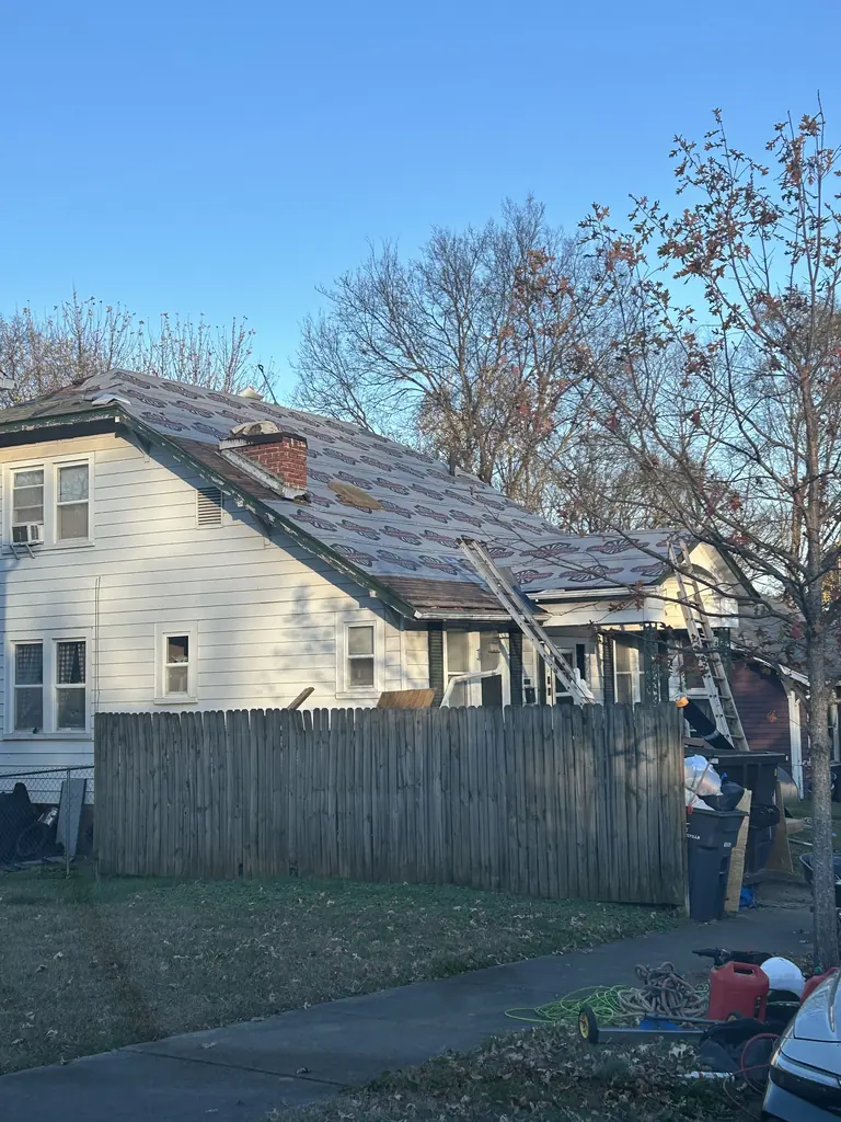 Roof tear-off in progress with the dumpster on site in Knoxville, Tennessee